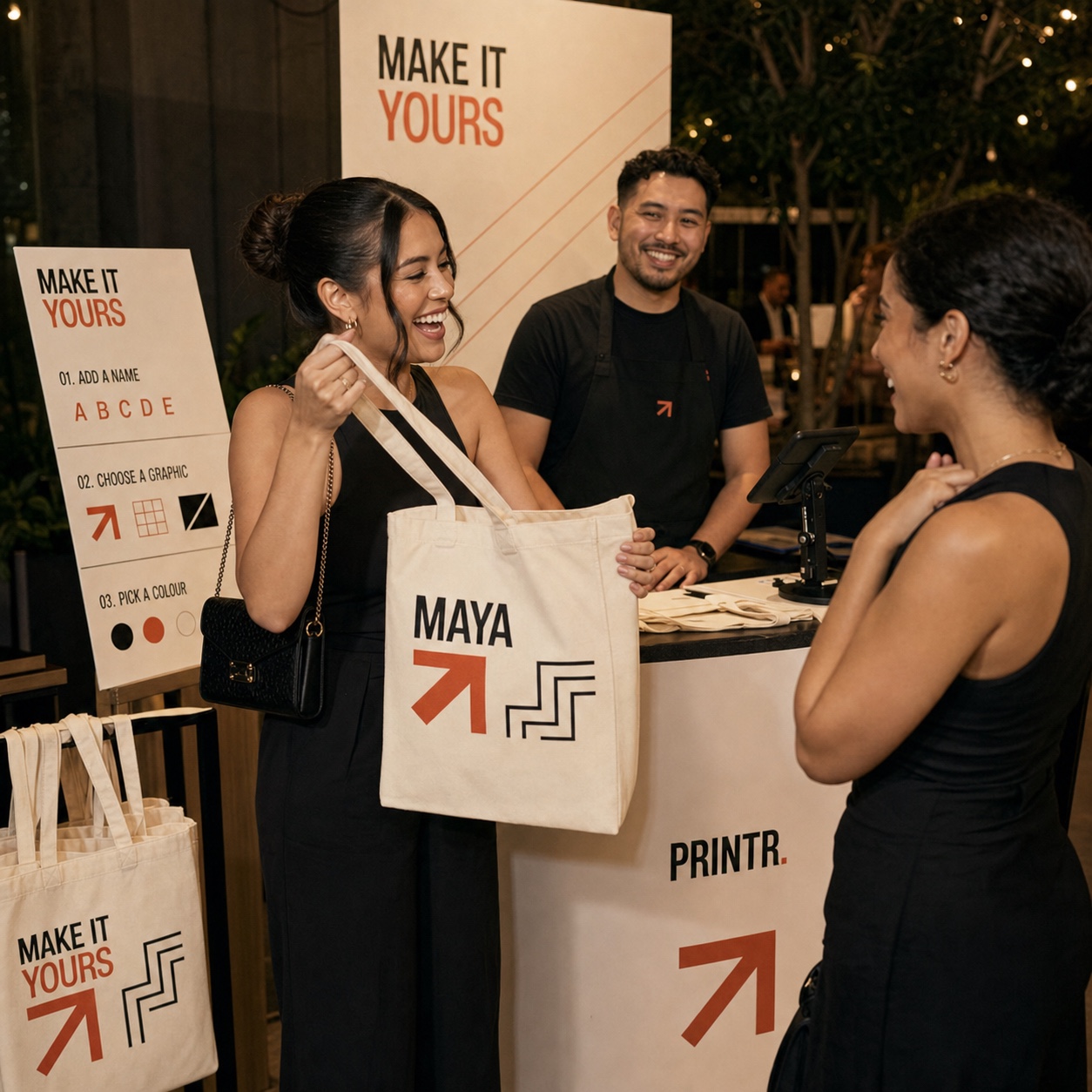 A guest receiving a personalised tote bag at a staffed Printr Live station