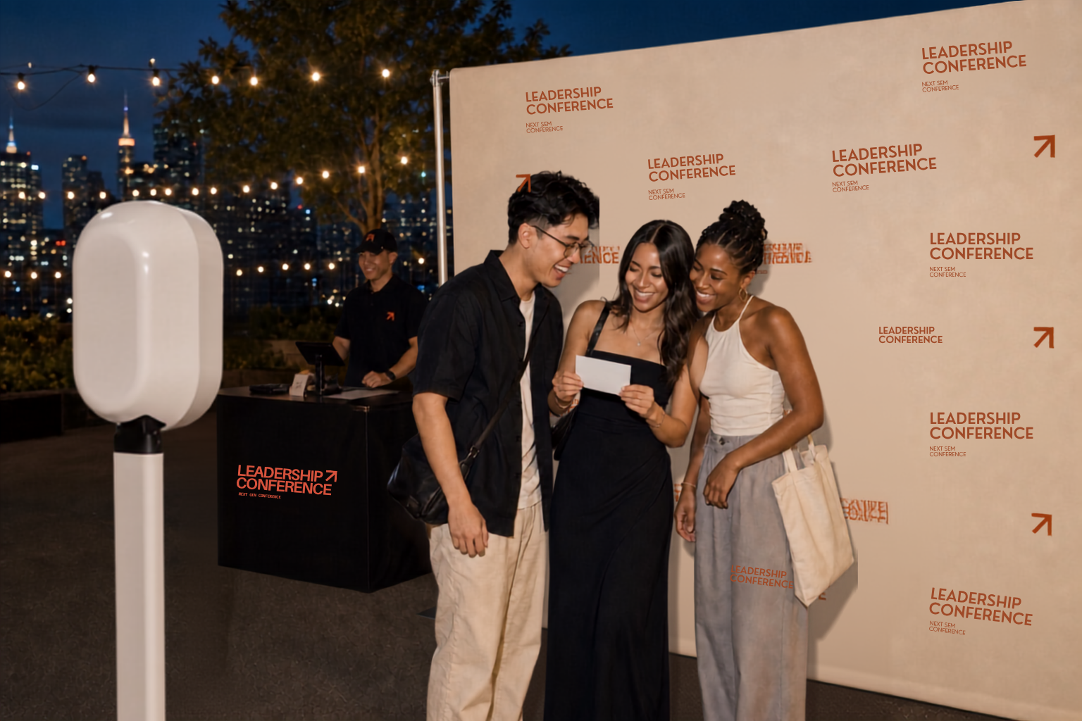 Three friends reviewing their printed photobooth photo at a staffed Leadership Conference activation